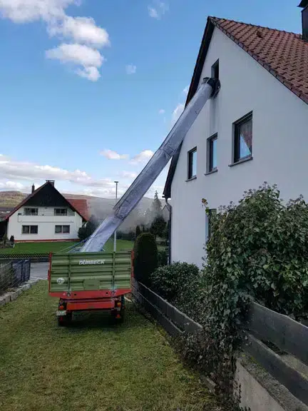 Flexible debris chute mounted on the building