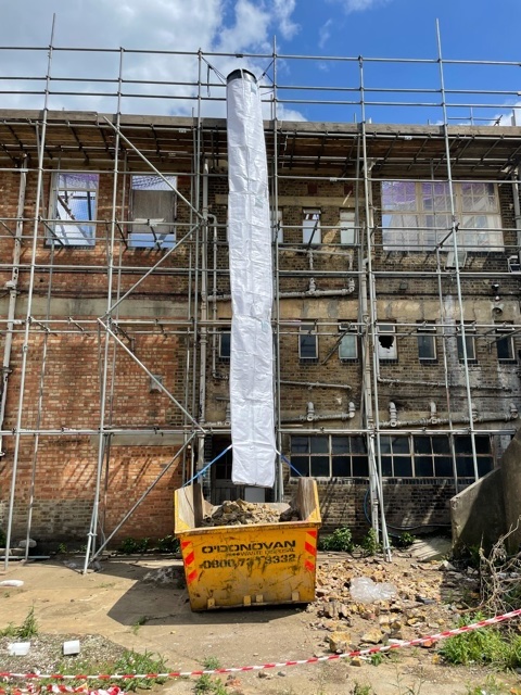 Flexible scaffold chute attached beside a scaffold